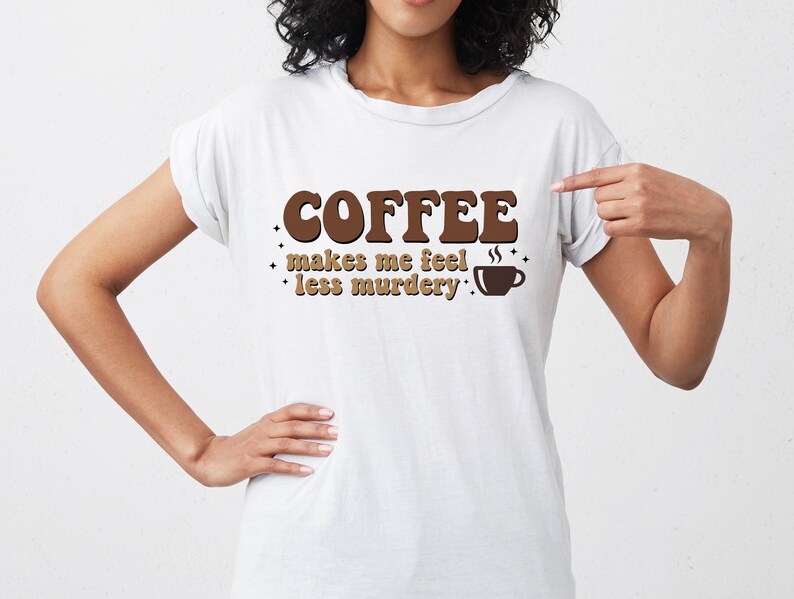 May include: White t-shirt with brown text that reads "Coffee makes me feel less murdery."  The text is in a retro font style with a coffee cup graphic.
