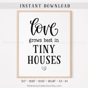 May include: A framed print with the words "love grows best in TINY HOUSES" in black script and block letters. A small heart is below the text. The print is in a light wood frame and includes size options.