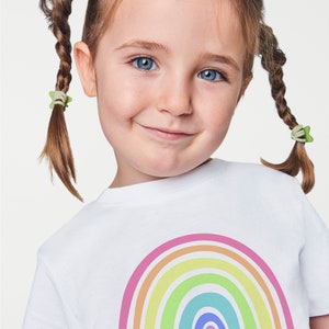 May include: A white t-shirt with a rainbow design and the text "hello SEVEN" in pink and blue.