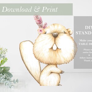 May include: Printable DIY stand-up of a cute cartoon beaver wearing a flower crown and feathers. The text "DIY STAND UPS! Make your own TABLE DECOR! Please read entire listing & follow instructions. Thank you!" is on a gray background.