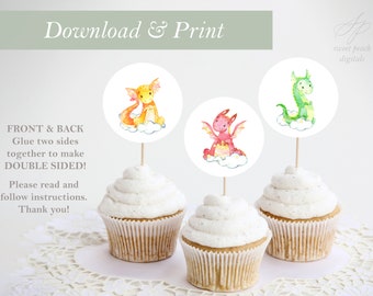 May include: Three cupcake toppers featuring watercolour illustrations of dragons. The dragons are yellow, red, and green. The toppers are on white circles with a cloud design. The text "Download & Print" and "Front & Back Glue two sides together to make Double Sided!" is visible at the top of the image.