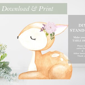 May include: Printable DIY stand-up of a fawn with a floral crown. The fawn is brown with white spots and has closed eyes. The floral crown is made of pink flowers and green leaves. The text "DIY STAND UPS! Make your own TABLE DECOR! Please read entire listing & follow instructions. Thank you!" is in the background.