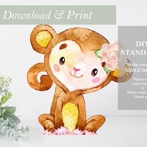 May include: A printable DIY stand-up of a cute cartoon monkey with a pink flower crown. The monkey is brown with yellow accents and has a heart-shaped body. The text "DIY STAND UPS! Make your own TABLE DECOR! Please read entire listing & follow instructions. Thank you!" is in the upper right corner of the image.