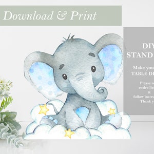 Puede incluir: Un stand-up de bricolaje imprimible de un elefante gris con orejas azules y una pajarita azul sentado en una nube blanca con estrellas amarillas. El texto "DIY STAND UPS! Make your own TABLE DECOR! Please read entire listing & follow instructions. Thank you!" está en el fondo.