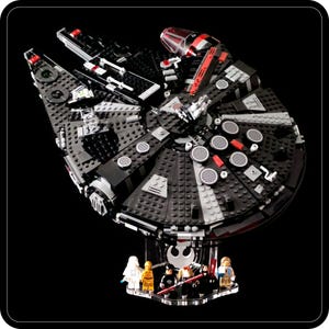 Könnte beinhalten: Ein schwarzes und graues LEGO Millennium Falcon Raumschiff mit roten Akzenten. Das Raumschiff wird auf einem klaren Acrylständer mit fünf LEGO Minifiguren präsentiert.