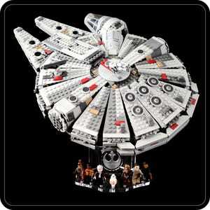 May include: A white and grey Lego Millennium Falcon spaceship with red accents. The spaceship is displayed on a black stand with a Rebel Alliance symbol.  The stand also features minifigures of the characters from the Star Wars film.