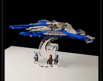 May include: A blue and white Lego Starfighter on a clear acrylic display stand with the text "LEGO Starfighter" on the stand. Three Lego minifigures are standing in front of the ship.