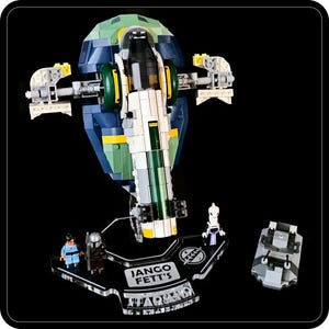 May include: A Lego model of Jango Fett's Slave I starship, with blue, green, and white panels. The set includes miniature figures and a display stand with the text "Jango Fett's" and "Star Wars" on it.