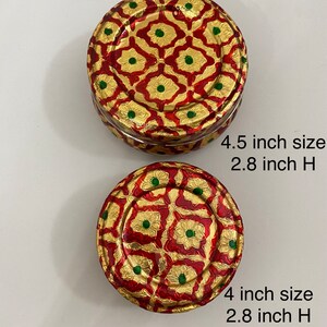 May include: Two round decorative boxes with intricate gold and red patterns. The larger box is 4.5 inches in diameter and 2.8 inches tall. The smaller box is 4 inches in diameter and 2.8 inches tall.