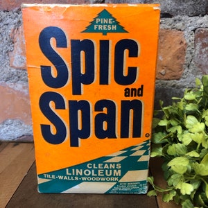 May include: A vintage box of Spic and Span cleaner with a pine-fresh scent. The box is orange with black lettering and a green pine tree logo. It says "Cleans Linoleum, Tile, Walls, Woodwork" and lists the active ingredients.