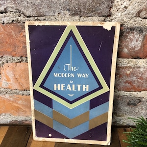 May include: A vintage book cover with a purple background and a green, blue, and brown geometric design. The text on the cover reads "The Modern Way to Health".