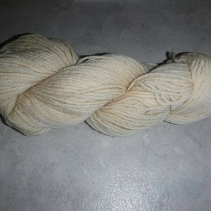 May include: A skein of off-white yarn, twisted into a loose coil.