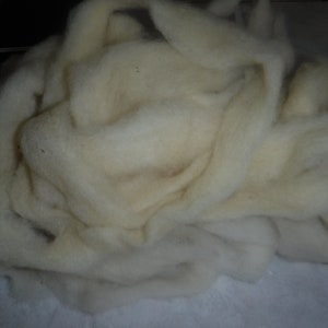 May include: A large pile of white wool roving. The wool is soft and fluffy, and it is perfect for spinning or felting.
