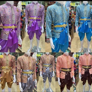 May include: Five different traditional Thai outfits with gold trim and patterned fabric. Each outfit includes a long-sleeved shirt, pants, and a sash with a gold buckle. The outfits are displayed on mannequins.