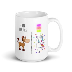 Op de afbeelding: Witte keramische koffiemok met een grappige illustratie die andere makelaars vergelijkt met een paard en de gebruiker met een eenhoorn. De tekst op de mok is "Other Realtors" en "Me! Me! Me!"