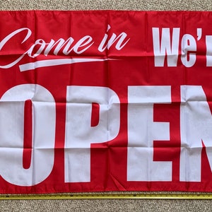 May include: Red and white open sign flag with the text "Come in We're OPEN".
