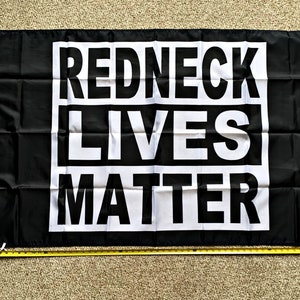May include: Black flag with white text that reads "Redneck Lives Matter".