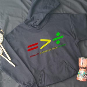 May include: Black hoodie with a graphic design of an equals sign, a greater than sign, and a division sign. The text "Equality is greater than division" is printed below the graphic.