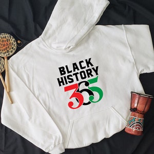 May include: White hoodie with a black, red, and green graphic that says "Black History 365".