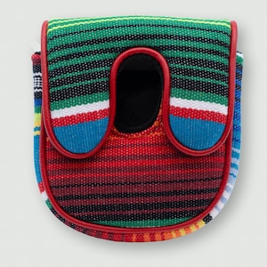 May include: A colorful golf club head cover with a striped pattern in green, black, red, blue, and white. The cover has a red trim and a black opening. The design is reminiscent of a woven textile.