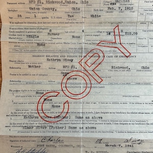May include: A black and white document with the title "Report of Induction of Selective Service Man" and a handwritten signature at the bottom. The document includes information about the inductee, including their name, address, birthdate, and military service information.