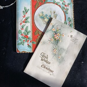 May include: A vintage Christmas card with a holly and bird design on the front and a message that reads "Good Wishes for a happy Christmas and a bright New Year".