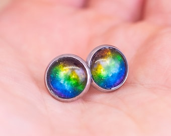 May include: A pair of silver stud earrings with rainbow galaxy-themed glass insets.