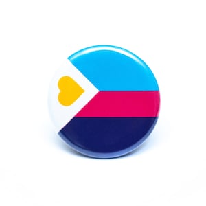 May include: A round button with a blue, pink, white, and dark blue striped design. A yellow heart is in the white triangle at the top of the button.