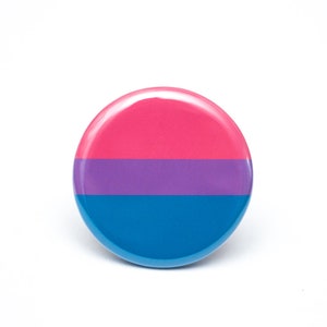 May include: A round button with the bisexual pride flag colors: pink, purple, and blue.