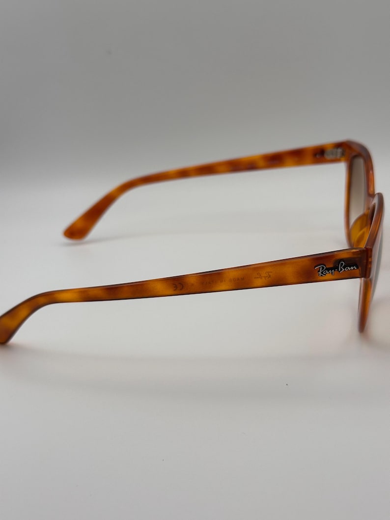 May include: Tortoiseshell sunglasses with brown lenses. The Ray-Ban logo is visible on the right arm. The frame has a classic, slightly rounded shape. The glasses are set against a plain white background.