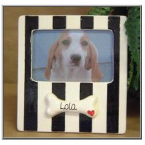 May include: White ceramic picture frame with black and white stripes. The frame has a bone-shaped cutout with the name "Lola" and a red heart.