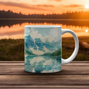 May include: White ceramic mug with a watercolor image of a mountain range reflected in a lake. The mountains are blue and green, and the lake is a light blue.