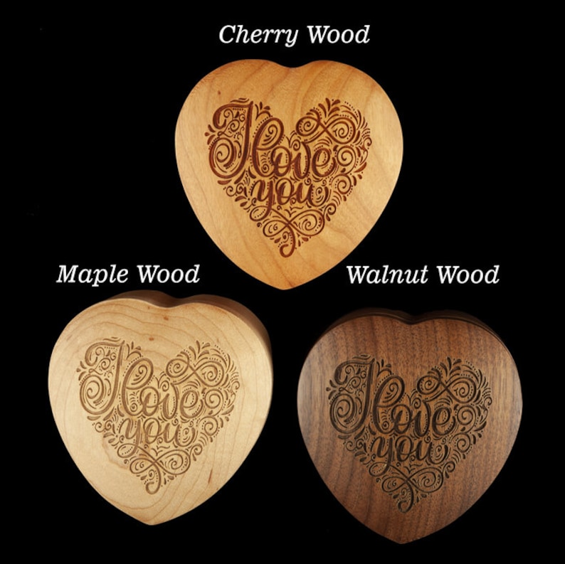 May include: Three heart-shaped wooden boxes with the words "I love you" engraved in a decorative script. The boxes are made of cherry, maple, and walnut wood.