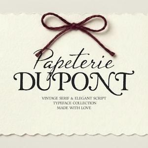 Peut inclure: Carte crème aux bords festonnés, avec le texte "Papeterie Dupont" en écriture élégante et polices serif. Un nœud en ficelle rouge foncé orne le dessus. La carte comprend également le texte "VINTAGE SERIF & ELEGANT SCRIPT TYPEFACE COLLECTION MADE WITH LOVE."