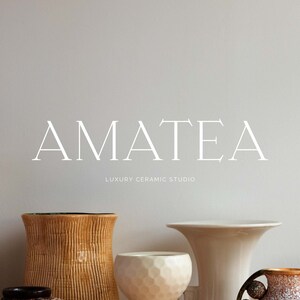 May include: A collection of ceramic vases in various shapes and sizes, including a tall, light brown vase, a shorter, wide-mouthed vase with a textured surface, and a small, round vase with a geometric pattern. The vases are arranged on a shelf in front of a white wall with the text "AMATEA LUXURY CERAMIC STUDIO" printed in white.