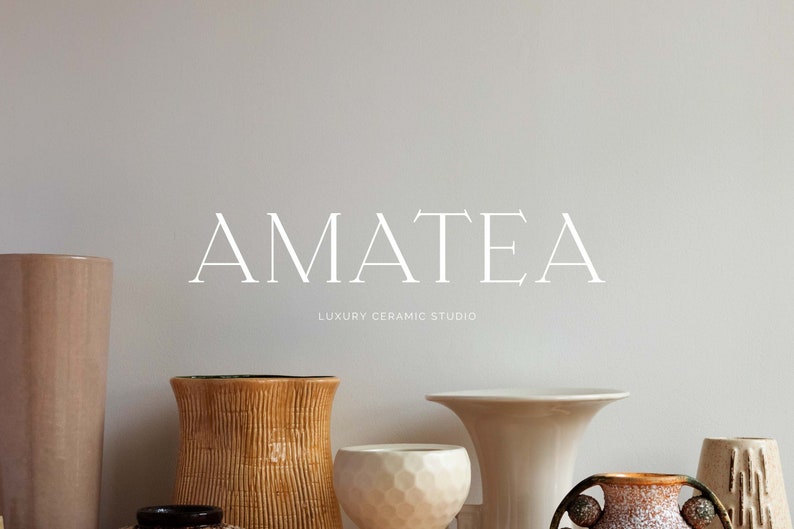 May include: A collection of ceramic vases in various shapes and sizes, including a tall, light brown vase, a shorter, wide-mouthed vase with a textured surface, and a small, round vase with a geometric pattern. The vases are arranged on a shelf in front of a white wall with the text "AMATEA LUXURY CERAMIC STUDIO" printed in white.