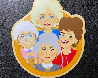May include: A circular sticker featuring a colorful cartoon illustration of four women with distinct hairstyles and clothing, including a blonde, a woman with white hair and glasses, a woman with grey hair, and a brunette wearing a red top and pearls.