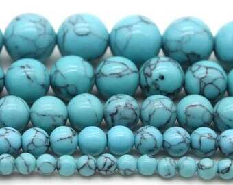 May include: A strand of turquoise beads in various sizes. The beads are a light blue color with dark blue veining.