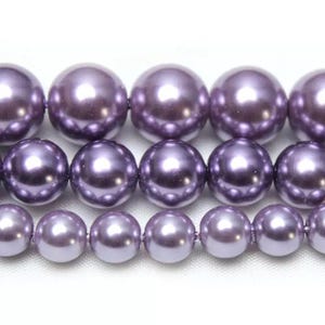 May include: A strand of purple pearl beads. The beads are round and have a smooth, glossy finish.