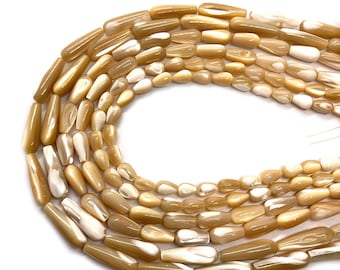 May include: A strand of beige and white shell beads with a pearlescent finish. The beads are long and narrow, resembling teardrops.