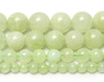 May include: A strand of light green jade beads in various sizes. The beads are round and smooth, and they are strung on a clear elastic cord.