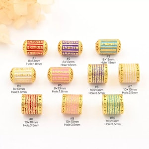 May include: Ten gold-plated barrel beads with enamel designs in various colours. Each bead has a different colour scheme, including red, purple, blue, white, pink, and green. Some beads measure 8x13mm, others 10x10mm, with hole sizes of 1.8mm and 3.5mm.