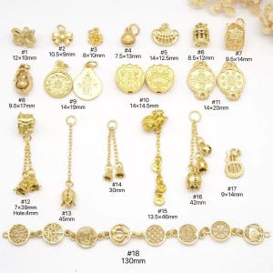 May include: A collection of gold-colored charms and pendants in various shapes and sizes. Includes bows, bells, and ornate designs, with measurements in millimeters. Ideal for jewelry making or crafting.