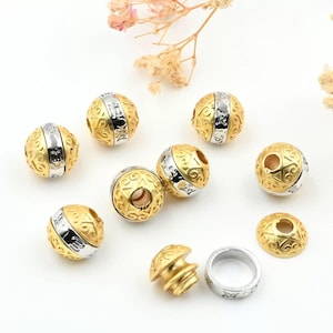 May include: Gold and silver-toned metal beads with intricate patterns. The beads are spherical with a silver band around the center. Some beads have a hole through the center. Additional components include a gold-toned bead cap and a silver ring.