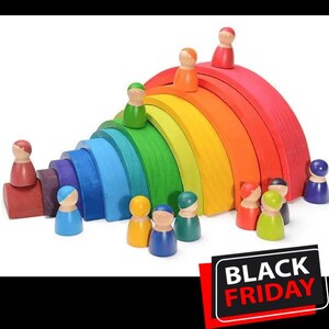 May include: A colorful wooden rainbow stacker toy with multiple arches in red, orange, yellow, green, blue, and purple. Small wooden peg people in various colors are arranged around the rainbow. A Black Friday sale sign is in the bottom right corner.