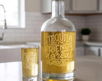 May include: A clear glass bottle and a matching shot glass, both filled with a golden liquid. Each piece features the etched white text: TEQUILA AND FRIENDS MAKE A GREAT MOOD. The bottle has a silver-colored cap and a cylindrical body design.