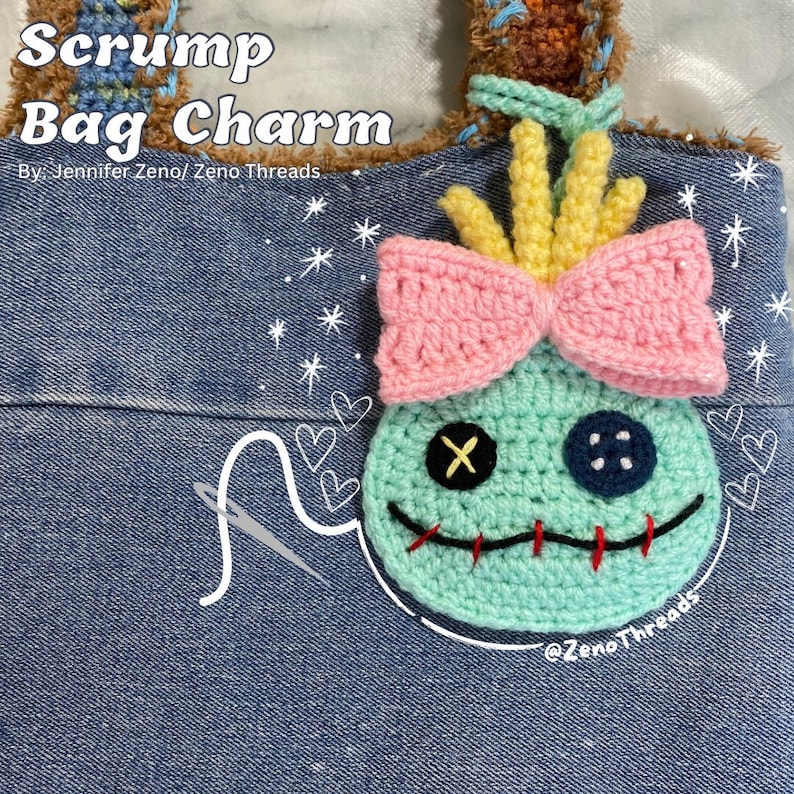 Pu&ograve; includere: Un ciondolo per borsa Scrump all'uncinetto con un fiocco rosa, capelli gialli e un occhio blu. Il ciondolo &egrave; attaccato a una borsa di jeans con il testo "Scrump Bag Charm" e "By: Jennifer Zeno/Zeno Threads" scritto su di essa.