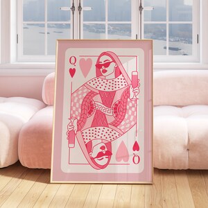 May include: A pink and white illustration of the Queen of Hearts playing card. The queen is wearing sunglasses and holding a glass of wine. The card is surrounded by hearts and a checkered pattern.