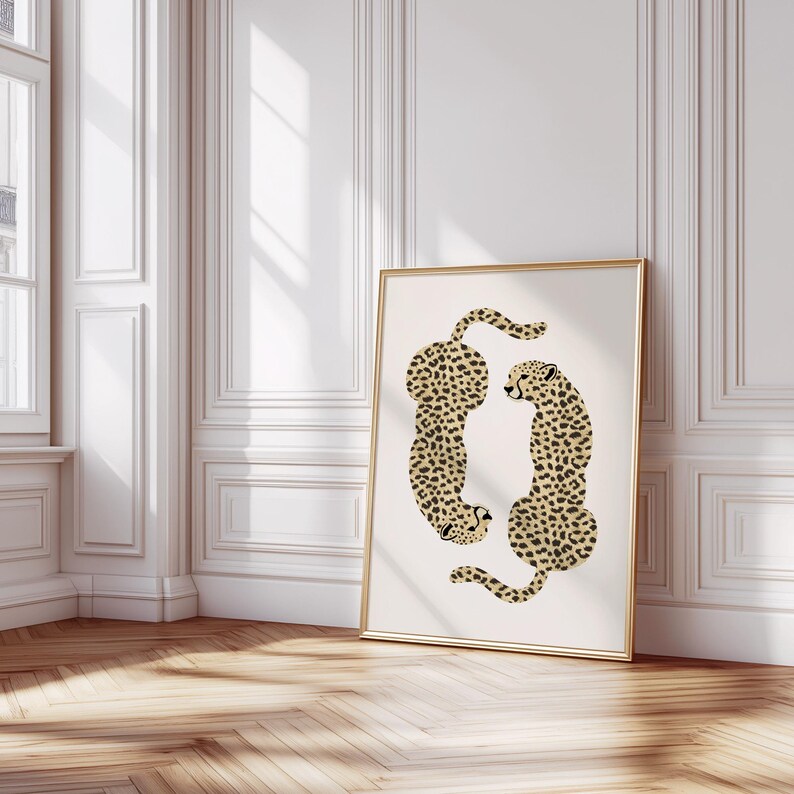 May include: A white framed print with two cheetahs in a curled position. The cheetahs are facing each other and have a black and tan spotted pattern.