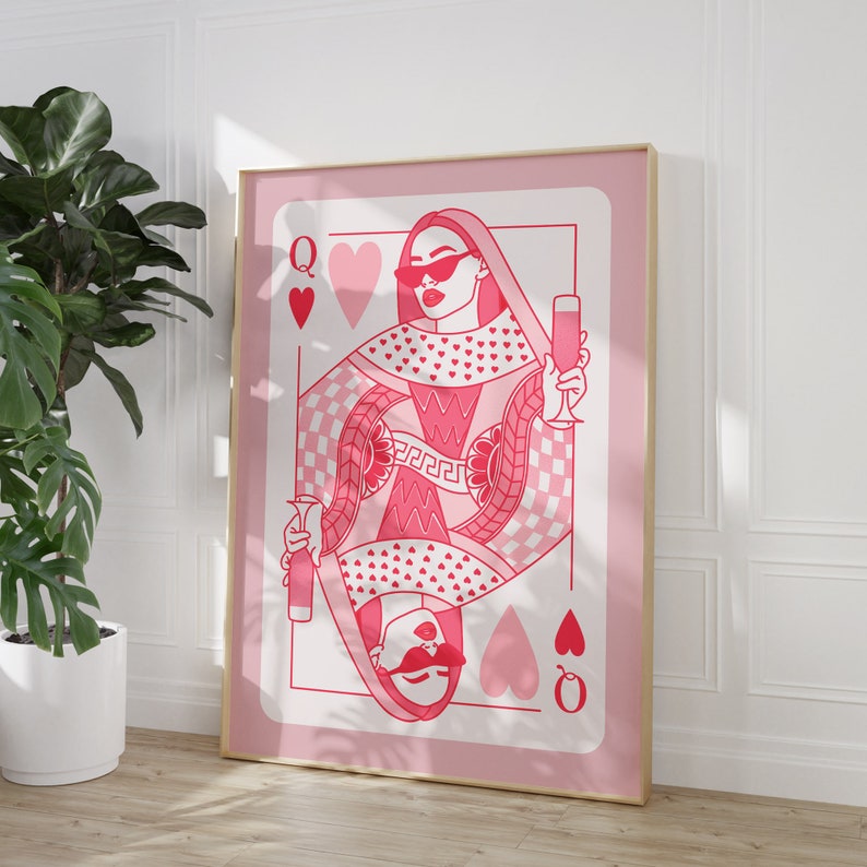 May include: A pink playing card with a queen of hearts design. The queen is wearing sunglasses and holding a glass of champagne. The card has a pink and white checkered pattern and is surrounded by hearts.